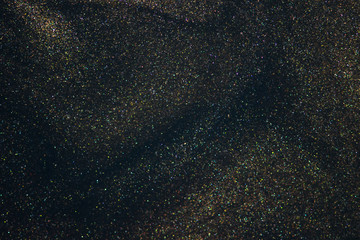 Fantasy bokeh glitter dust on dark magic background.