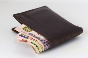 200 Egyptian pound bills in a dark brown wallet isolated on a white background 
