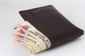 200 Egyptian pound bills in a dark brown wallet isolated on a white background 