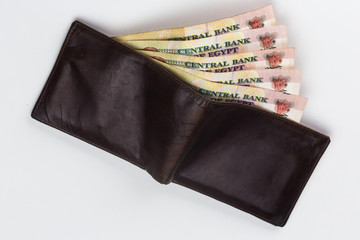 200 Egyptian pound bills in a dark brown wallet isolated on a white background  - obrazy, fototapety, plakaty