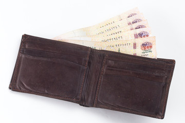 200 Egyptian pound bills in a dark brown wallet isolated on a white background 