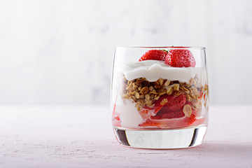close up of dessert with strawberry, granola and cottage cheese on pink background with copy space