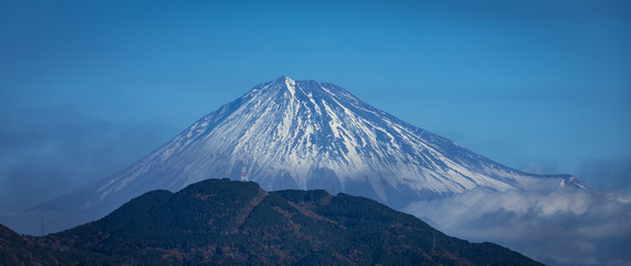 Mt Fuji with a smaller mountain in front of it and a small radio tower