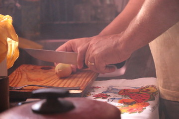 Mão masculina cortando cebola