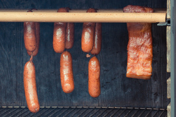 Smoked sausages meat hanging in smokehouse, traditional food