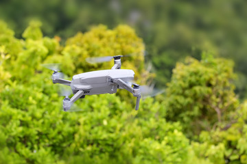 Drones while flying up from the floor with trees and nature