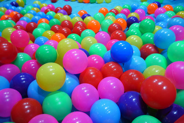 many colorful plastic balls filled child pool suitable for kids at indoors children's playground.