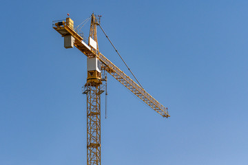 concrete construction yard building site yellow crane in front of blue sky background