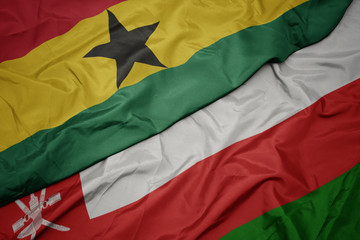 waving colorful flag of oman and national flag of ghana.