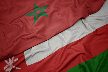 waving colorful flag of oman and national flag of morocco.
