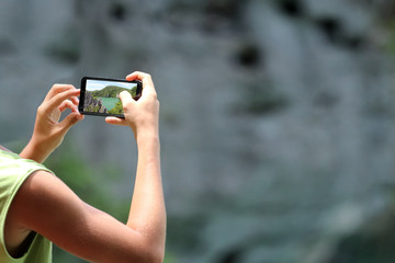 Travelers using Mobile phone and cameras take picture of mountains and lakes