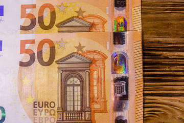 Fifty euro banknotes on the wooden background. Top view