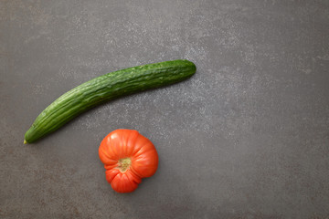 Un concombre et une tomate sur un fond uni