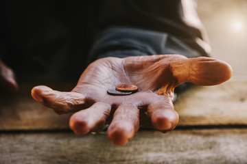 hand old man begging for money because of the hunger on the wood table. vintage tone