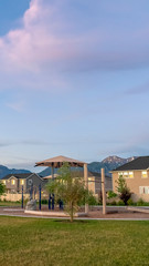 Vertical frame Peaceful neighborhood with playground and pavilion in front of family homes