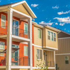 Square Multi storey home exterior with sunlit balconies and white and orange wall