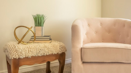 Panorama frame Cozy chair and wooden side table inside a room with white wall and carpet floor