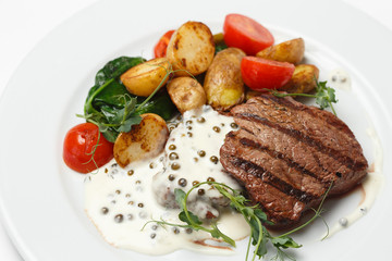beef steak with baked potatoes and vegetables