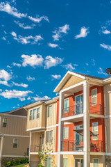 Multi storey home exterior with sunlit balconies and white and orange wall