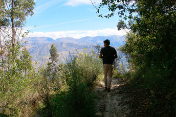 Happy man walking on dirt road in the Peruvian altiplano valley.