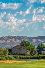 Pond and grassy terrain in front of houses with view of the valley and mountain
