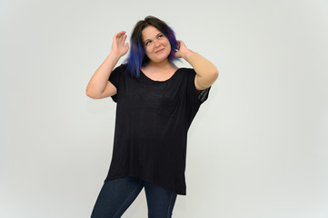 Stock Foto Portrait of a knee-deep funny cheerful girl of a young woman with multi-colored hair in a black T-shirt on a white background. In the studio, smiling, talking.