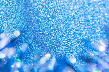 Beautiful blue tinsel on glitter background for festive design.