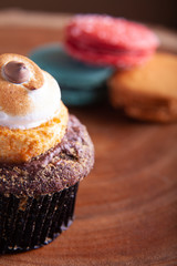 Cupcake and Macaroons close up on wood platter