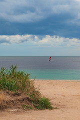 Fototapeta na wymiar Lonely windsurfer under the clouds