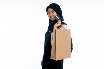 Asian woman with shopping bag while holding a card on white background