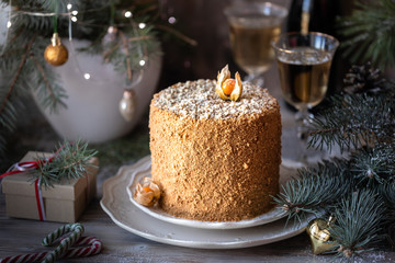 Homemade honey cake. Winter composition. New Year photo. Christmas decoration. Christmas decorations. Cake with sparklers. garland on a tree. Champagne in the glasses