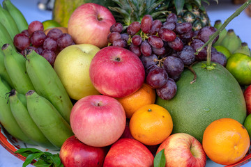 Naklejka na ściany i meble Assortment of fresh fruit banana, grapes, orange, apple, pineapple, tangerine and grapefruit on a tray. Closeup