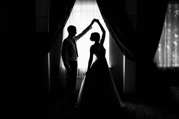 Bride and groom at the window. Silhouette of the bride and groom at the window. Silhouette of...
