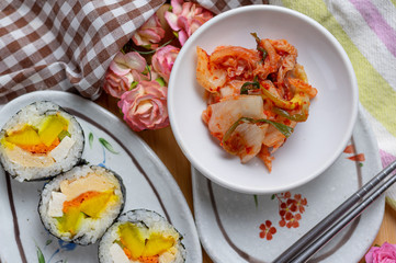 Kimchi and Gimbap serving on white plate