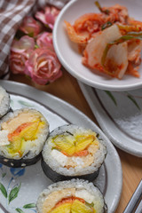 Kimchi and Gimbap serving on white plate