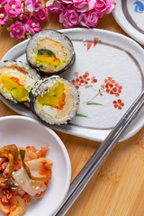 Kimchi and Gimbap serving on white plate