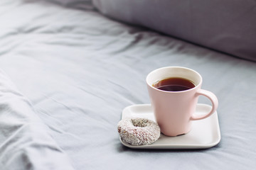 Tea with dessert, lazy breakfast on grey bed at sunday