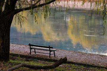 Lonely wooden bench whit gorgeous view at the river/ Beautiful autumn river scenery/ Place for...