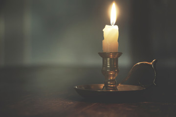dim light of a candle in a mysterious night, concept of spirituality and hope