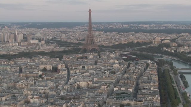 Aerial drone shot of the famous Eiffel Tower in Paris, France with many buildings in the foreground and the cityscape in the background