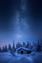 Small hay barn at winter morning blue hour covered by snow in Finland