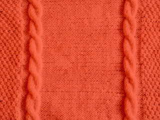 Texture of knitted woolen sweater dyed in Living Coral. Color of the year 2019 concept