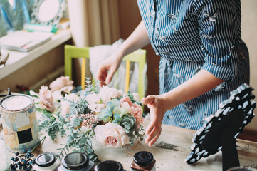 Small business. Florist girl creates a flower arrangement in her decor studio. Hands close-up