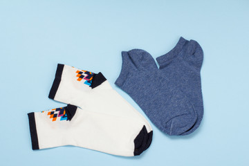 White and dark blue cotton women socks on blue background.