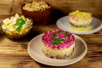 Set of festive mayonnaise salads on wooden table