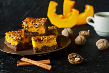 Food for Halloween. Homemade chocolate brownie with nuts and a layer of pumpkin. Coffee with cakes