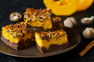 Food for Halloween. Homemade chocolate brownie with nuts and a layer of pumpkin. Coffee with cakes