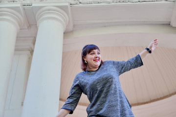 Nice funny cute girl in gazebo with white columns in the park