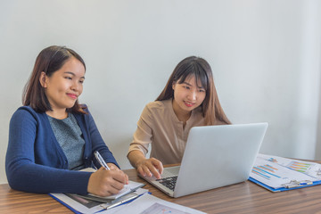Asian female financial advisors using laptop and having business discussion 