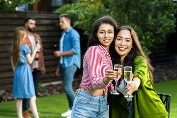 Cute young girls with drinks looking at camera